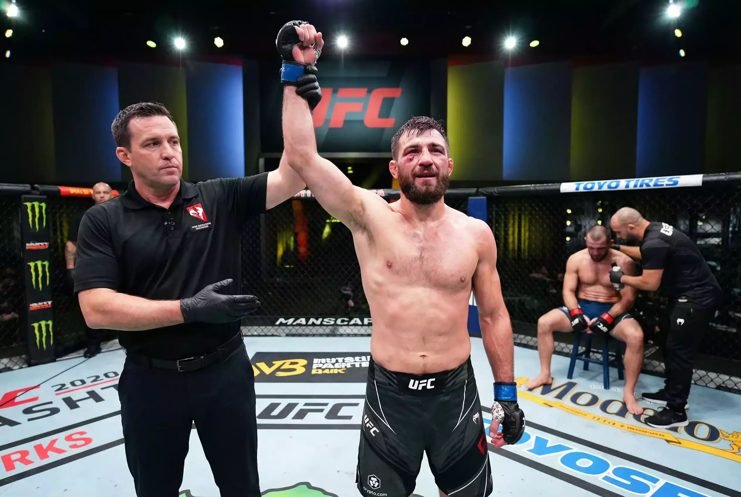 Ringrichter hebt den Arm des siegreichen MMA-Kämpfers