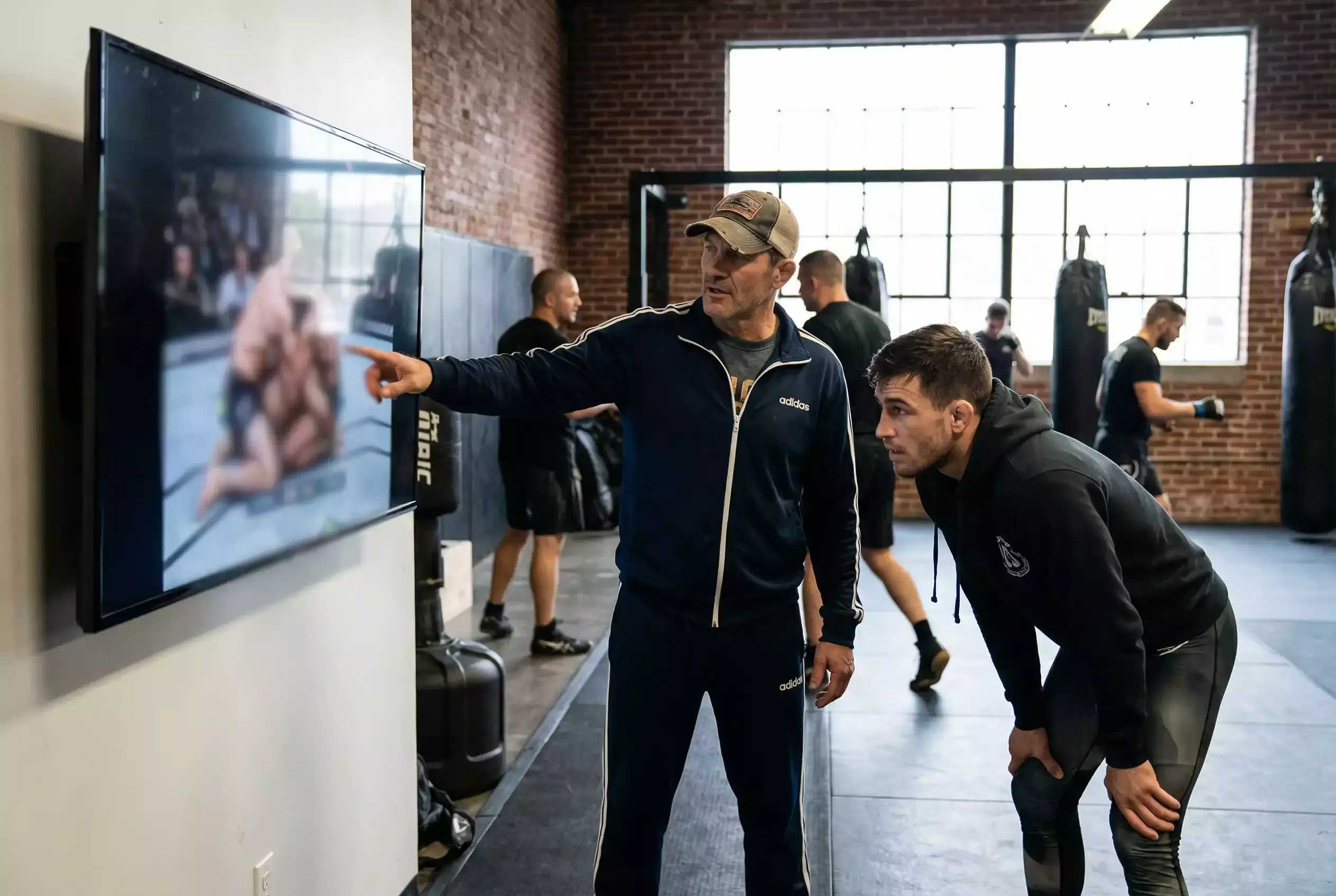 Trainer analysiert Kampfaufnahmen mit Athleten